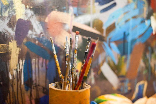 brushes for drawing in a glass against the background of a canvas. brushes for drawing at art school.