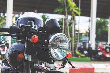 close up. vintage motorcycle on the road with a helmet. over light and retro tone [blur and select...
