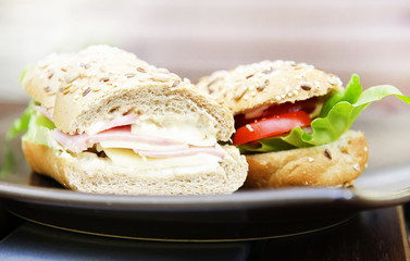 Sandwich with ham, cheese, tomato slice and lettuce leaf