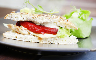 Sandwich with chicken meat, lettuce leaf and hot sauce