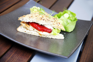 Sandwich with chicken meat, hot sauce and lettuce leaf