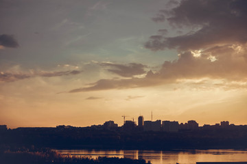 Naklejka na ściany i meble Beautiful sunset over silhouette city skyline and river
