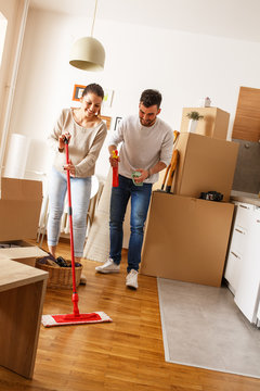 Young couple cleaning and selecting things at they new home.Moving house.
