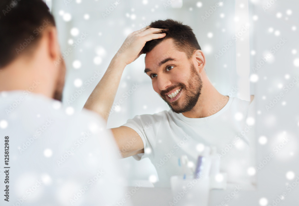 Wall mural happy young man looking to mirror at home bathroom