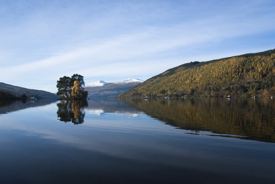 A autumnal looking landscape image of Loch Tay and the Isle of Spar with Ben Lawers in the background.