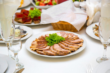 sliced sausage on a plate. Beautifully decorated table
