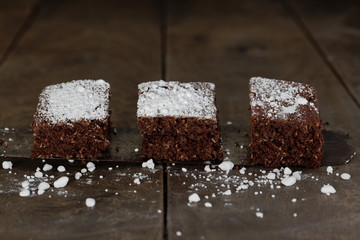 drei stücke Brownies mit Puderzucker, rustikal