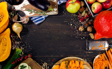 Autumn vegetables and fruits on a dark wooden board.