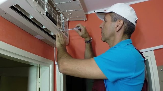 Air Conditioning Installation / Engineer with screwdriver installing air conditioner. HD1080p