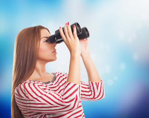 portrait of a beautiful young woman looking through the binoculars