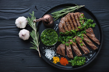 Grilled rumpsteaks with chimmichurri sauce in a frying pan