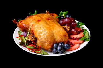 Roast duck with fruit on black background