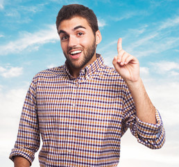 portrait of a handsome man pointing up with finger