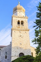 Obraz premium Bell tower of cathedral, Church of the Assumption of Blessed Virgin Mary,in Krk, Croatia, monument of Romanesque era St Quirinus & Barbara, with a Venetian sculpture of angel holding a trumpet on top.