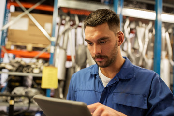 auto mechanic or smith with tablet pc at workshop