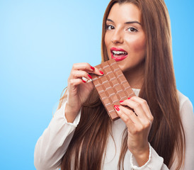 portrait of a pretty girl biting a chocolate bar