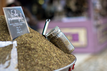 Erbe provenzali speziate in recipiente di acciaio con barattolo di vetro