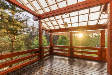 Large Porch of the log cabin at sunset with forest view