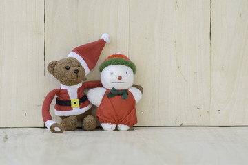 Obraz premium Stuffed Santa Claus and snowman on the wooden floor.