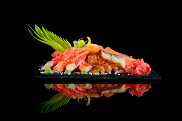 Sashimi seafood assortment on a black background with reflection