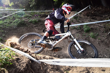 Sport race Mountain biker extreme and fun downhill track. Jumps and dirt splashes.