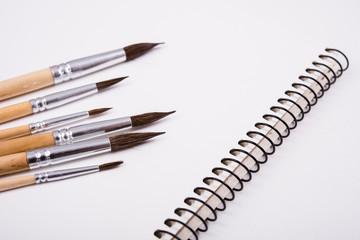Watercolor paint brushes and clean paper on artist's work desk