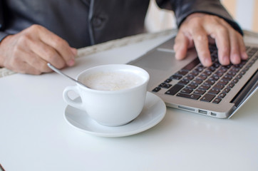 Aged man is using laptop