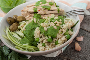 vegan zucchini pasta with tofu, bulgur, green peas, olives and pesto of parsley in a jar. vegetables every day for your health!
