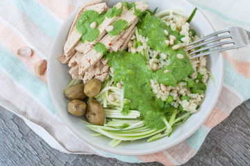 vegan zucchini pasta with tofu, bulgur, green peas, olives and pesto of parsley in a jar. vegetables every day for your health!