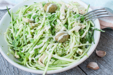 vegan zucchini pasta with tofu, bulgur, green peas, olives and pesto of parsley in a jar. vegetables every day for your health!