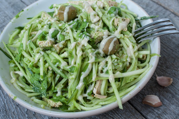 vegan zucchini pasta with tofu, bulgur, green peas, olives and pesto of parsley in a jar. vegetables every day for your health!