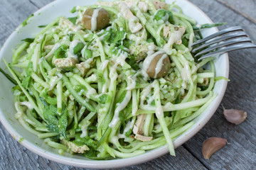 vegan zucchini pasta with tofu, bulgur, green peas, olives and pesto of parsley in a jar. vegetables every day for your health!
