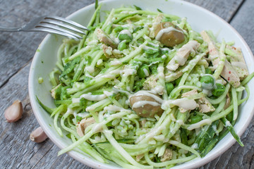 vegan zucchini pasta with tofu, bulgur, green peas, olives and pesto of parsley in a jar. vegetables every day for your health!