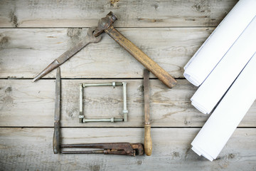 The concept of a house under construction. Old wooden desktop. Old rusty carpentry tools. Horizontal mockup