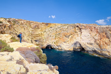 Hiker on the cliffs of Blue Grotto, Malta