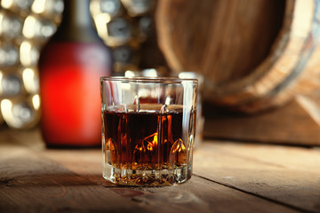 Glass of whiskey, bottle and wooden barrel