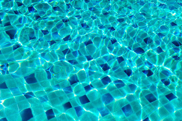 Water serface waves in swimming pool with sunlight reflections
