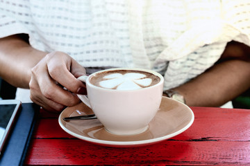 Women hand handle coffee cup in coffee shop