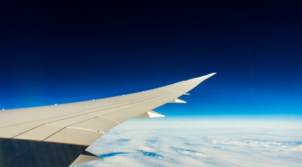 Obraz na płótnie Canvas Aircraft wing in flight with wingflex and dark blue sky (Boeing 787)