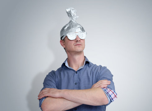 Funny man in a cap of aluminum foil. Concept art phobias
