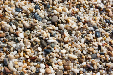 Group of multicolored sea round stones forming colored background. Wet pebbles