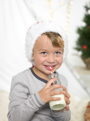 junge trinkt milch und hat weihnachtsmütze auf