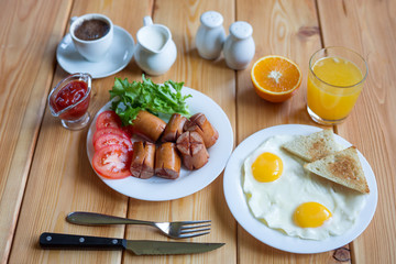 Orange juice, coffee cup, eggs and sausage for healthy breakfast