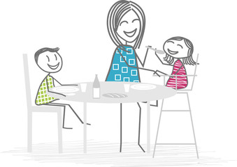 Une mère ou nounou fait manger un jeune enfant autour d'une table, un deuxième enfant mange seul