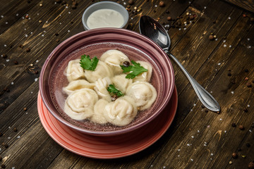 dumplings in broth on a wooden background