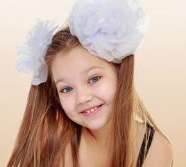 Beautiful little girl with white bows on the head