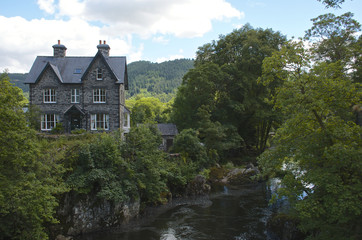 Obraz premium House beside a river, summers day in Beytws y coed
