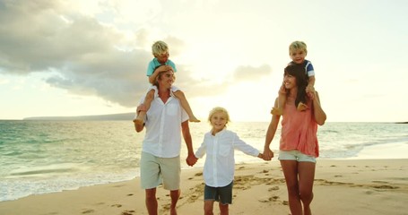 Happy family walking down the beach at sunset - Powered by Adobe