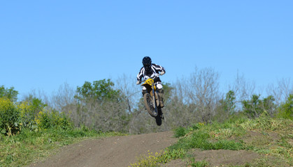 Naklejka premium Jump/Motocross rider jumping a small hill.
