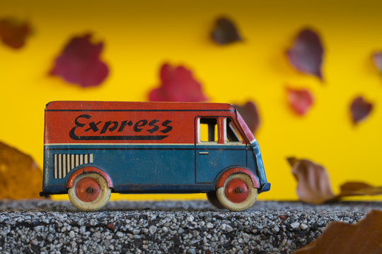 Van for express deliveries traveling in the fall. Antique toy car in autumn landscape.